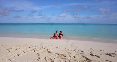 年轻的男孩女孩度蜜月假期享受奢侈品海滩清洁白色沙子背景